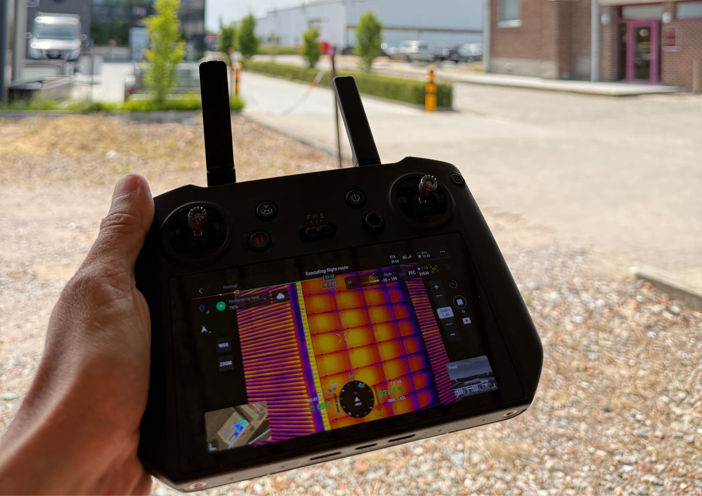 Dronecontroller met een live thermisch beeld van een dak met zonnepanelen
