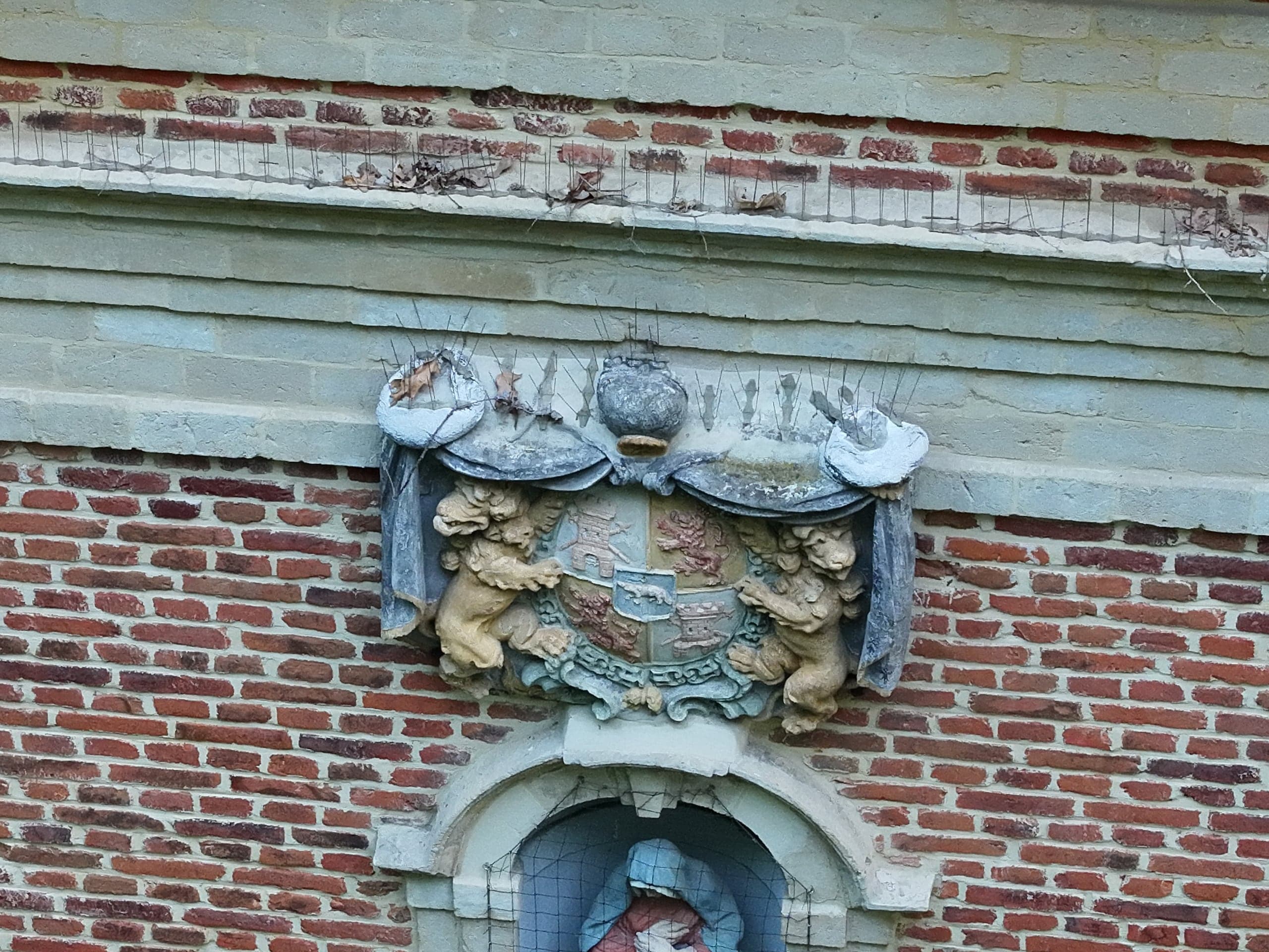 Gebeeldhouwd wapenschild in de bakstenen gevel van de Boskapel in Imde