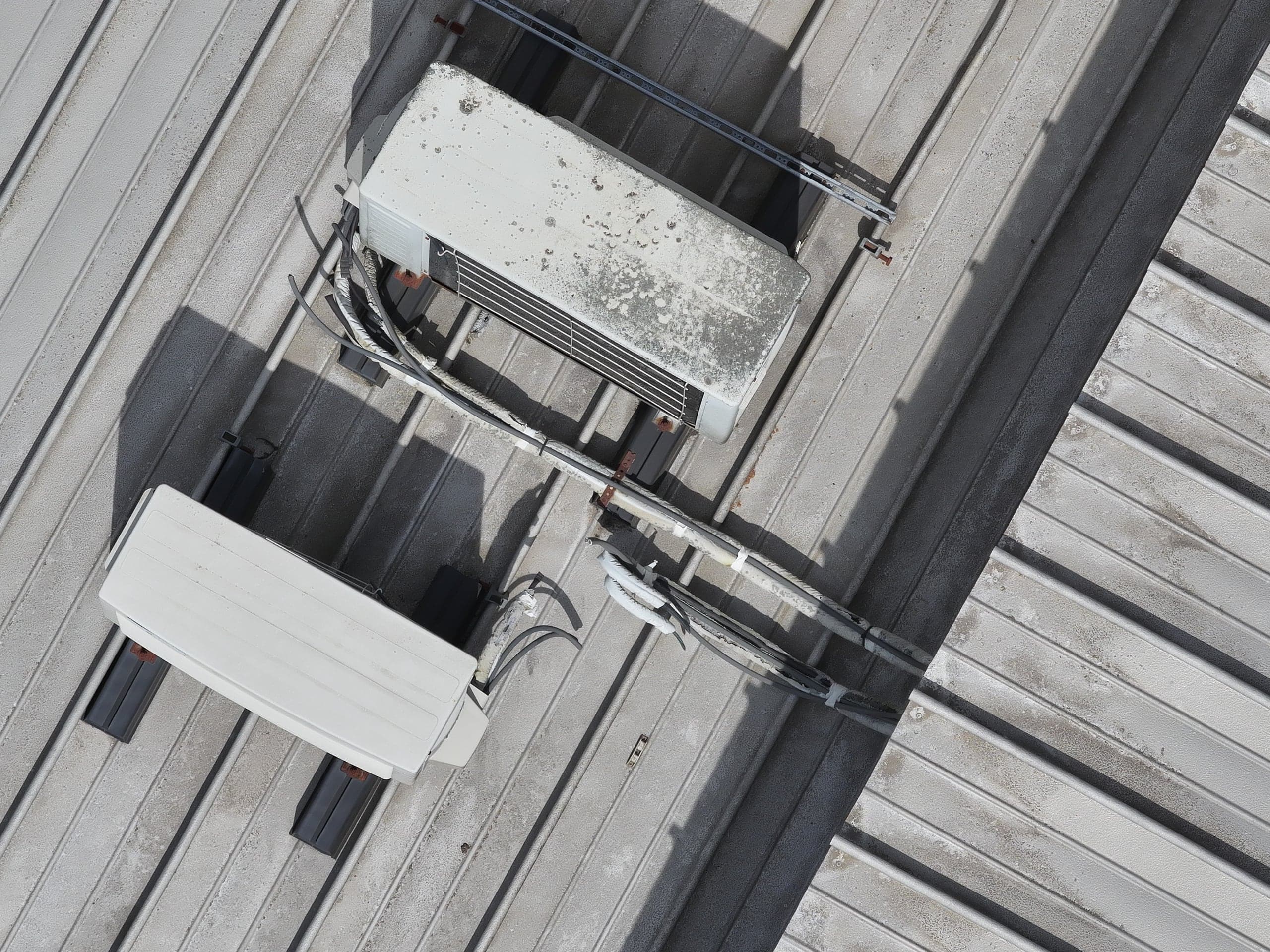 Twee HVAC-units met leidingen op een metalen dak