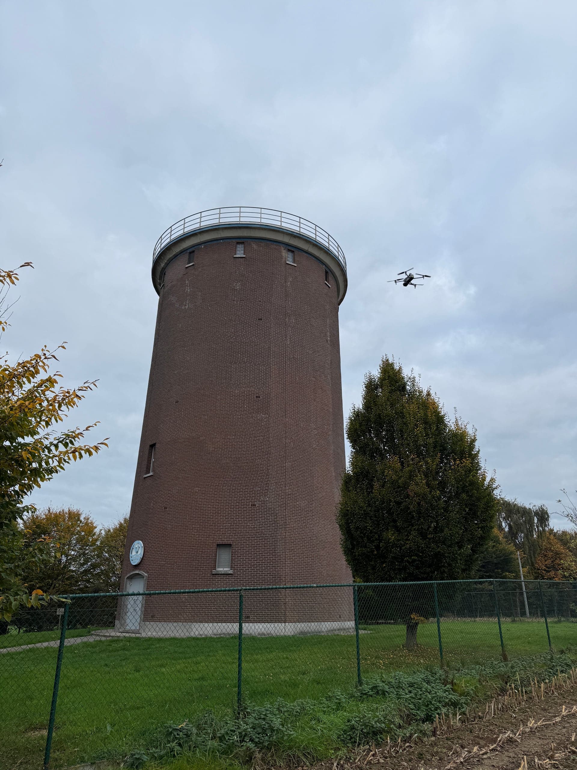 De drone in vlucht naast de watertoren in Brussegem